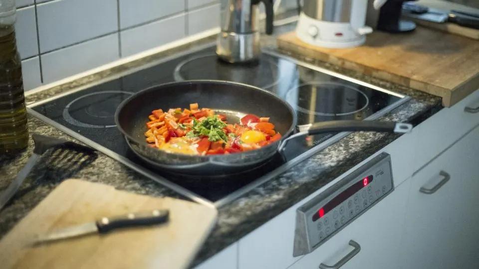 Frigideira com comida no fogão de uma cozinha