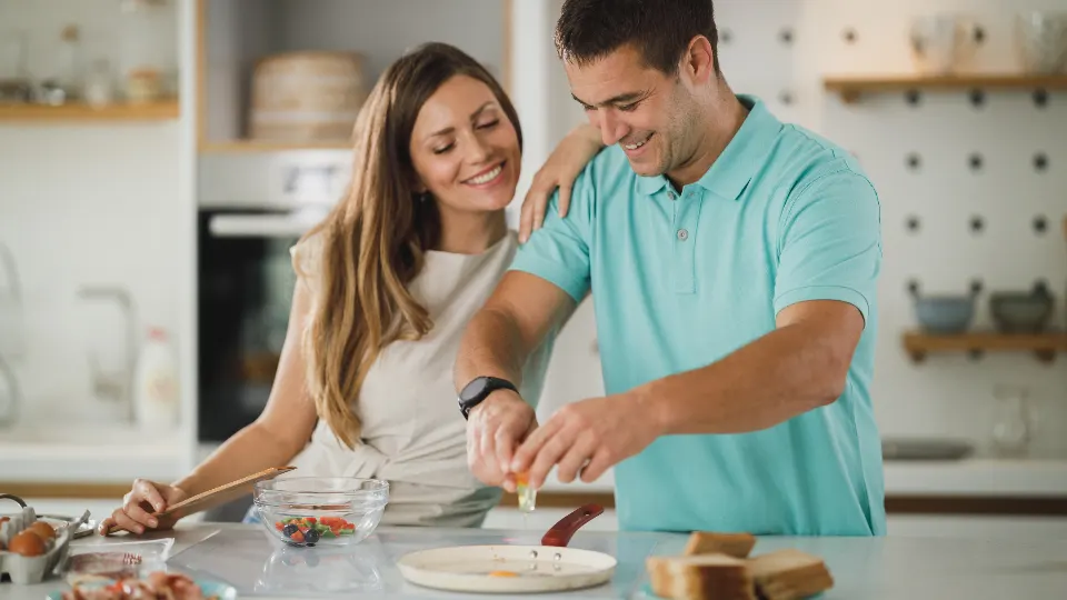 Casal preparando comida junto na cozinha
